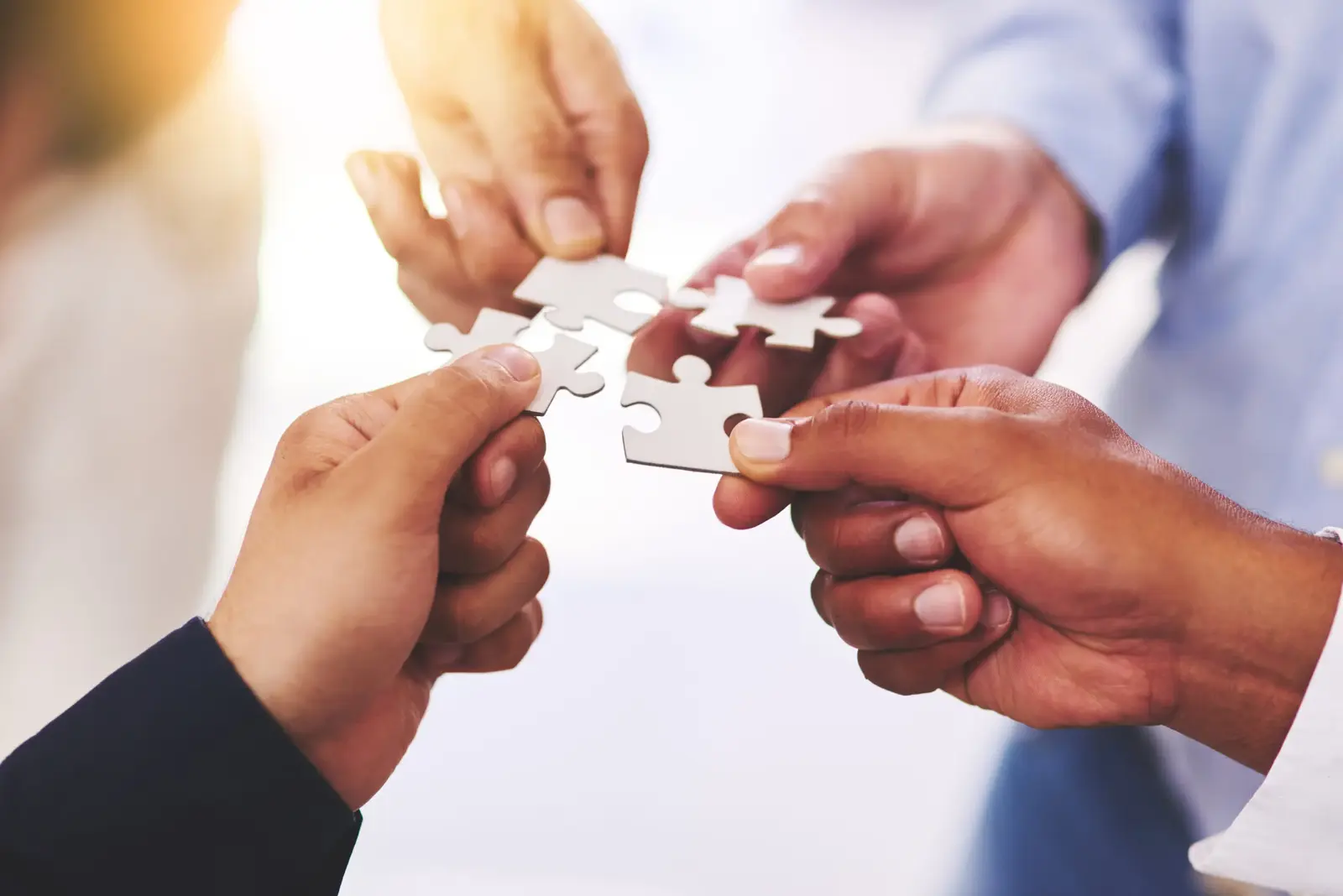 Hands joining puzzle pieces together