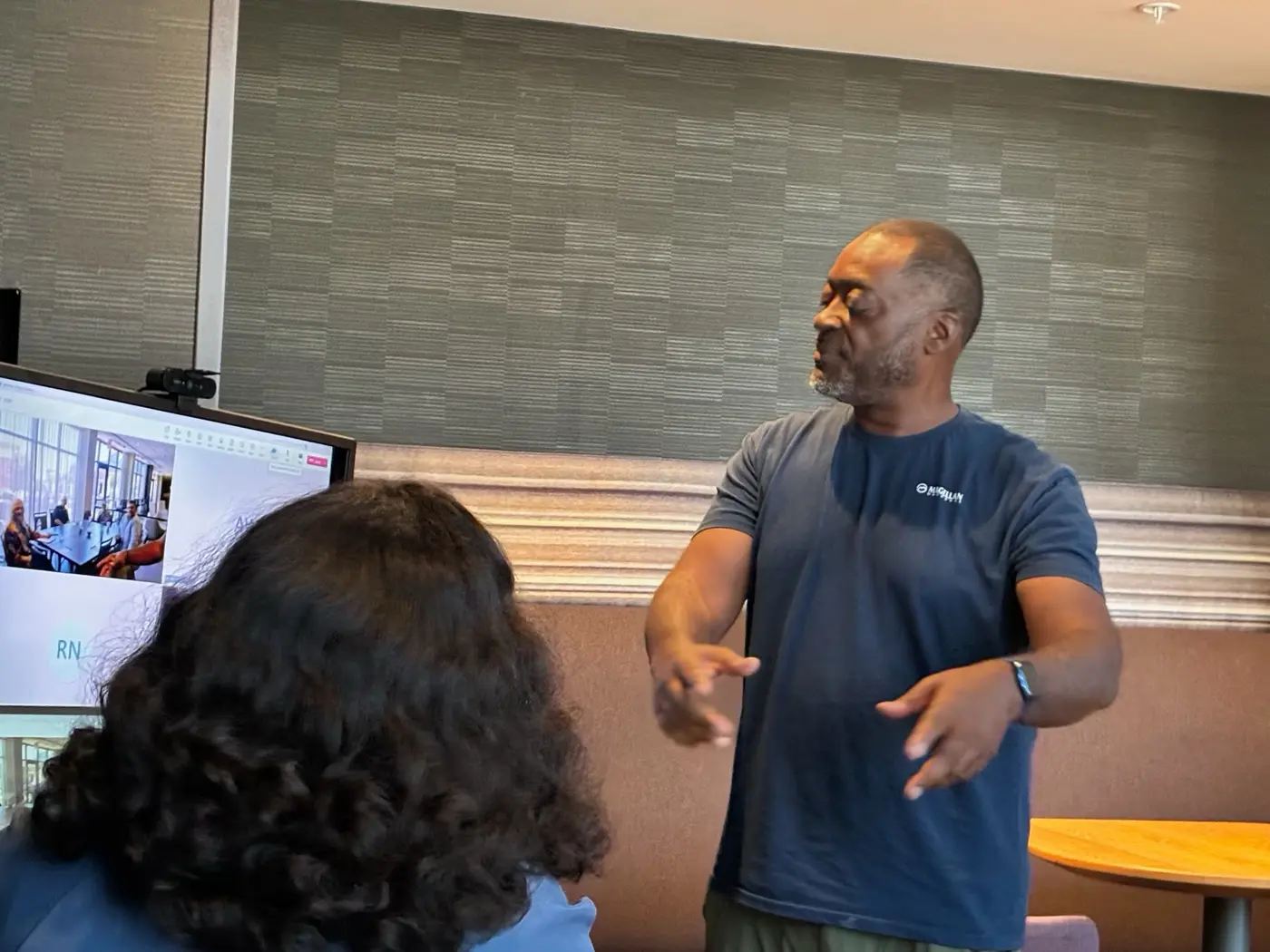 Melvin teaching a session in Cartersville, the room joined by others on a video call