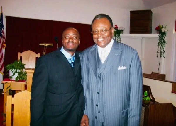 Melvin Green standing beside his uncle, Pastor Floyd Jones, in the pulpit area of the sanctuary