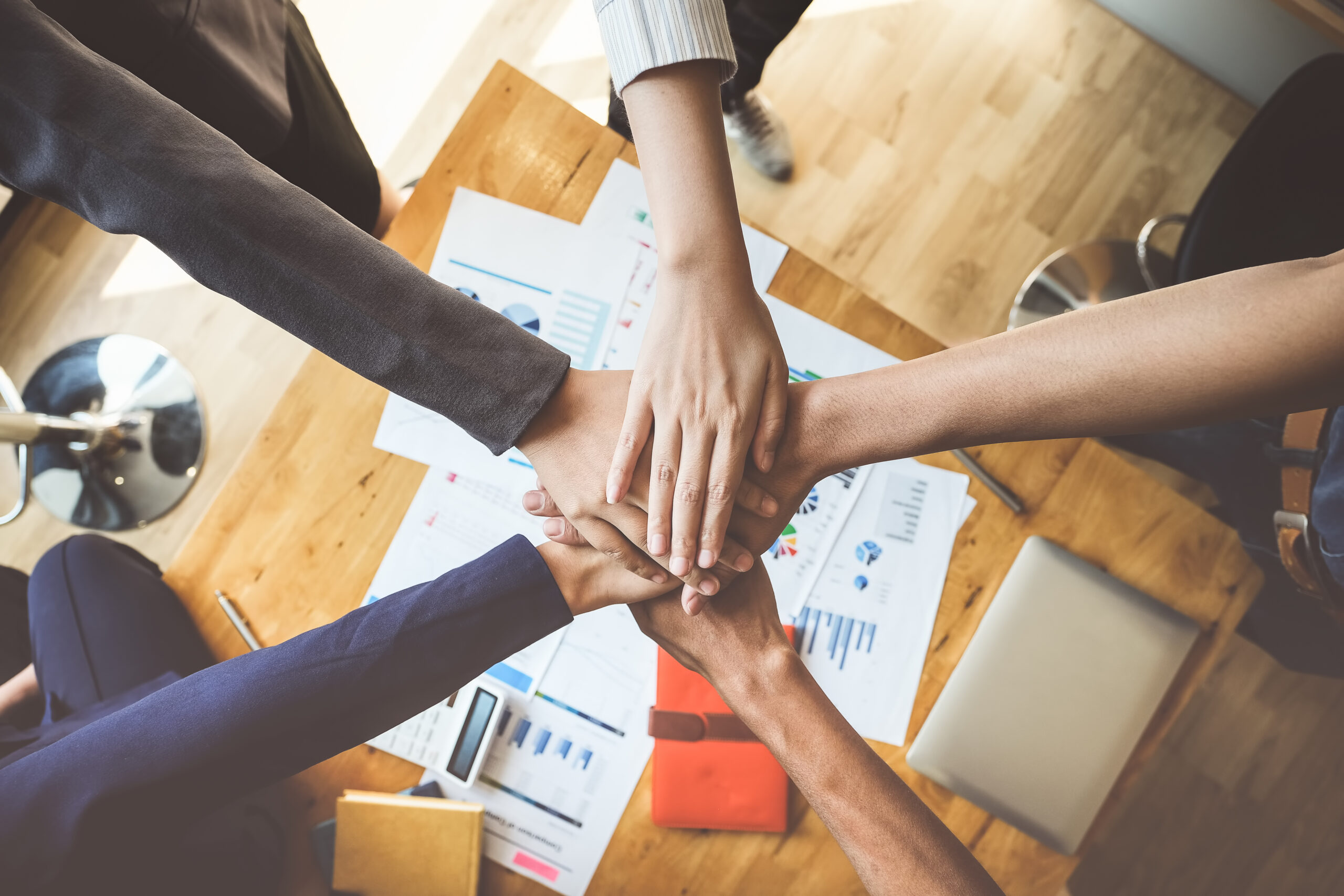 young people putting their hands together. partnership with stack of hands showing unity and teamwork.